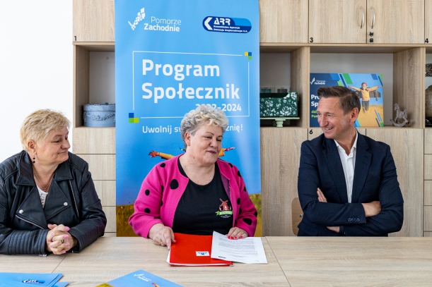 podpisanie umów z programu społecznik. za stołem cztery osoby