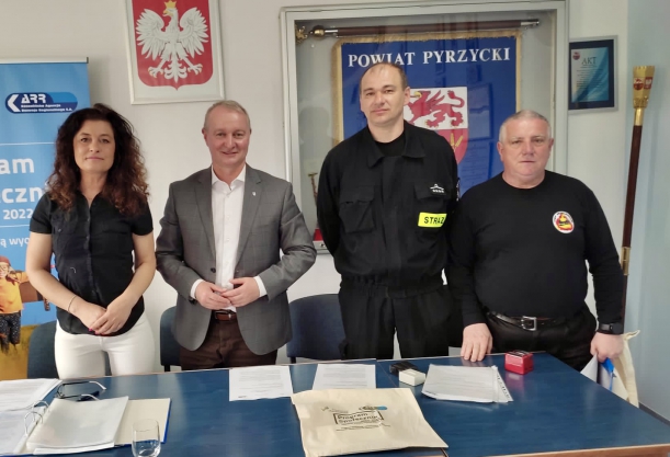 Strażacy OSP po podpisaniu umowy z prpgramu Społecznik, stoja za stołem 