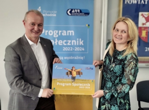 Katarzyna Kucharska i Olgierd Kustosz trzymają tablicę promocyjną Programu Społecznik 